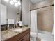 Bathroom with granite countertop, dark wood vanity, and tile shower/tub at 1417 Terralago Pl, Oviedo, FL 32765
