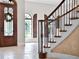 Entryway featuring decorative glass door, a staircase with iron railings, and arched windows with wooden shutters at 1417 Terralago Pl, Oviedo, FL 32765