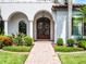 Grand entryway featuring a brick walkway, arched doorway, columns, a chandelier, and detailed wreaths at 1417 Terralago Pl, Oviedo, FL 32765