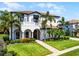 Elegant two-story home featuring a tile roof, arched entryway, a small balcony, and manicured lawn at 1417 Terralago Pl, Oviedo, FL 32765