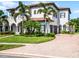 Stunning two-story home featuring a tile roof, arched entryway, lush landscaping, and a brick driveway at 1417 Terralago Pl, Oviedo, FL 32765