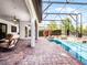 Relaxing outdoor area with a screened-in pool, brick patio, and ample seating at 1417 Terralago Pl, Oviedo, FL 32765