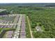 Expansive aerial view capturing a residential neighborhood adjacent to a dense green forest and serene lakes at 1580 Delphi Way, New Smyrna Beach, FL 32168
