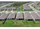Aerial view of homes showcasing backyard spaces, a tranquil pond, and lush greenery at 1580 Delphi Way, New Smyrna Beach, FL 32168