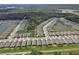 Overhead view showcases a community with houses lining waterways and lush landscape near a vast green forest at 1580 Delphi Way, New Smyrna Beach, FL 32168