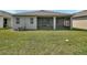 The covered patio provides an ideal space for outdoor relaxation, overlooking the green backyard at 1580 Delphi Way, New Smyrna Beach, FL 32168