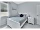 This bedroom features neutral walls, a window, a white bed frame, and a matching nightstand at 1580 Delphi Way, New Smyrna Beach, FL 32168