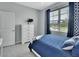 Chic bedroom with a modern white bed, bright natural light, and stylish blue accents at 1580 Delphi Way, New Smyrna Beach, FL 32168
