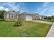 Charming single-story home with a manicured lawn and beautiful landscaping under a sunny blue sky at 1580 Delphi Way, New Smyrna Beach, FL 32168