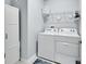 This laundry room has a new washer and dryer and white cabinets for storage at 1580 Delphi Way, New Smyrna Beach, FL 32168