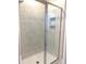Modern bathroom features a frameless glass shower with sleek marble-patterned tile and a recessed shelf at 16454 Silver Brook Way, Winter Garden, FL 34787