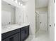 Bathroom featuring double sink vanity with a large mirror and a glass-door shower at 16454 Silver Brook Way, Winter Garden, FL 34787