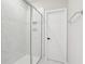 Bathroom shower featuring glass doors, white marble-style tile, and built-in shower niche at 16454 Silver Brook Way, Winter Garden, FL 34787