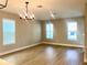 Bright and airy living room showcasing hardwood floors and natural lighting from two large windows at 16454 Silver Brook Way, Winter Garden, FL 34787