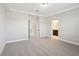 A primary bedroom shows a tray ceiling, neutral paint, plush carpet, and open doorway to an ensuite bath at 16454 Silver Brook Way, Winter Garden, FL 34787