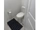 Powder bathroom featuring commode, gray tile floor and black and white rug at 1900 Erudite Way, Winter Park, FL 32792