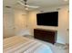 Bright bedroom features ceiling fan, large TV, and stylish dark wood dresser at 1900 Erudite Way, Winter Park, FL 32792