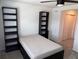 Bedroom featuring a simple bed setup with dark shelving units, enhanced by neutral colored carpet at 1900 Erudite Way, Winter Park, FL 32792