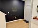Modern entryway with wood-look floors, a dark accent wall with geometric art, and a bright white front door at 1900 Erudite Way, Winter Park, FL 32792
