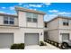 Attractive townhome with a gray two-car garage, manicured front yard, and well-lit entryway at 1900 Erudite Way, Winter Park, FL 32792