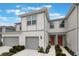 Charming two-story townhouse featuring a one-car garage, neutral paint scheme, and landscaped walkway to the front door at 1900 Erudite Way, Winter Park, FL 32792