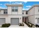 Charming two-story townhouse featuring a one-car garage, neutral paint scheme, and landscaped walkway to the front door at 1900 Erudite Way, Winter Park, FL 32792