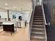 Open-concept view of the modern kitchen and carpeted staircase with wrought iron railing at 1900 Erudite Way, Winter Park, FL 32792