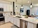 Bright kitchen featuring white cabinetry, stainless steel appliances, a center island, and modern pendant lighting at 1900 Erudite Way, Winter Park, FL 32792