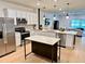 Bright kitchen featuring white cabinetry, stainless steel appliances, a center island, and modern pendant lighting at 1900 Erudite Way, Winter Park, FL 32792