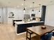 Open kitchen and dining area with an island, stainless steel appliances, and dark-stained wood table at 1900 Erudite Way, Winter Park, FL 32792