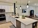 Bright kitchen featuring white cabinetry, stainless steel appliances, a center island, and modern pendant lighting at 1900 Erudite Way, Winter Park, FL 32792