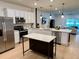 Kitchen featuring stainless appliances, white cabinets and a center island, open to the living area at 1900 Erudite Way, Winter Park, FL 32792