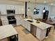 Bright kitchen featuring white cabinetry, stainless steel appliances, a center island, and modern pendant lighting at 1900 Erudite Way, Winter Park, FL 32792