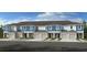Charming new townhomes featuring coordinated color schemes, garages and manicured lawns at 2208 Portrait St, Kissimmee, FL 34758