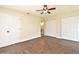 Spacious bedroom featuring wood-look tile floors, ceiling fan, and dual closets for organized storage at 2524 Shadybranch Dr, Orlando, FL 32822