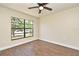 This bedroom features wood look flooring, a ceiling fan, and a large window at 2524 Shadybranch Dr, Orlando, FL 32822