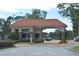 Gated community entrance featuring a guard house with tile roof and manicured landscape at 2524 Shadybranch Dr, Orlando, FL 32822