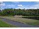 Scenic view of the community entrance sign, 'Ventura', surrounded by lush greenery, tropical trees, and a pond at 2524 Shadybranch Dr, Orlando, FL 32822