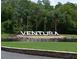 Community entrance sign 'Ventura' at the center of a pond surrounded by palm trees and lush landscaping at 2524 Shadybranch Dr, Orlando, FL 32822