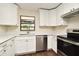 Well-lit kitchen showcasing stainless steel dishwasher and range, bright cabinetry, and a view to the garden at 2524 Shadybranch Dr, Orlando, FL 32822