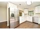 Stylish kitchen featuring stainless steel appliances, white cabinets, and wood-look tile flooring at 2524 Shadybranch Dr, Orlando, FL 32822