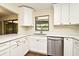 Eat-in kitchen featuring stainless dishwasher and bright cabinets with a pass-through window to the backyard at 2524 Shadybranch Dr, Orlando, FL 32822