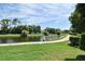 Scenic view of a tranquil pond with lush landscaping and a peaceful walking path; white railings for safety at 2524 Shadybranch Dr, Orlando, FL 32822