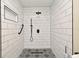 Bathroom shower with white subway tile surround, niche, and decorative tile flooring at 2524 Shadybranch Dr, Orlando, FL 32822
