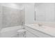Bathroom featuring shower-tub combo with gray tile surround, and vanity with quartz countertop at 2716 Pierr St, Davenport, FL 33837
