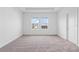 A bright, neutral bedroom with carpet floors and double windows overlooking a backyard at 2716 Pierr St, Davenport, FL 33837
