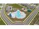 Aerial view of a large community pool area with lounge chairs, a playground, and ample parking at 2716 Pierr St, Davenport, FL 33837