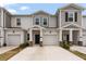 A view of the townhouse exterior with neutral paint, garage, and well-kept landscaping at 2716 Pierr St, Davenport, FL 33837