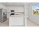 Well-lit kitchen with white cabinetry, quartz countertops, stainless steel appliances, and an island at 2716 Pierr St, Davenport, FL 33837