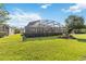 Expansive backyard featuring a screened-in pool area, surrounded by manicured greenery and mature trees at 2746 Windsorgate Ln, Orlando, FL 32828